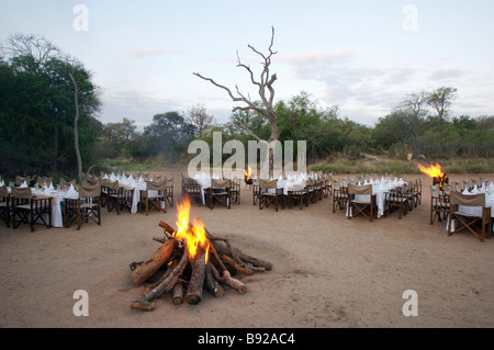 Feu de joie au milieu de table et chaises pour repas Kapama Lodge province du Limpopo, Afrique du Sud Banque D'Images