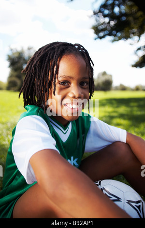 Garçon assis avec ballon de soccer Zoolake Park Gauteng Johannesburg Afrique du Sud Banque D'Images