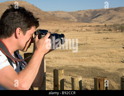 Jeune homme de prendre une photo du Parc National de Pilanesberg North West Province Afrique du Sud Banque D'Images