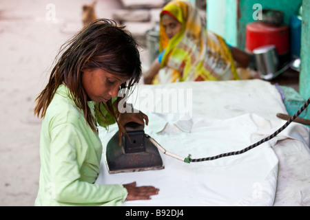 Jeune indienne travaillant dans une blanchisserie Service de repassage des vêtements dans Fatehpur Sikri Inde Banque D'Images