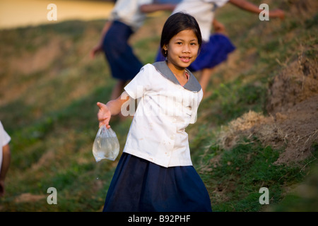 Jeune fille cambodgienne portant de l'eau retour à la classe à l'école secondaire Roesey Chroy Banque D'Images