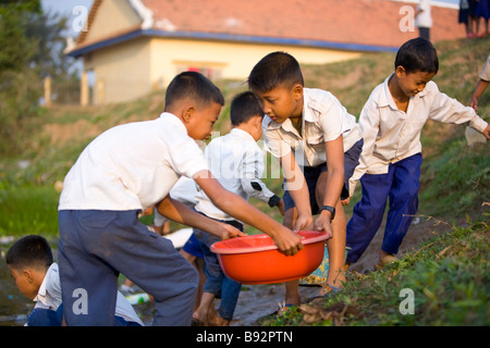 Les jeunes enfants cambodgiens collecte d'eau à l'école secondaire Roesey Chroy Banque D'Images