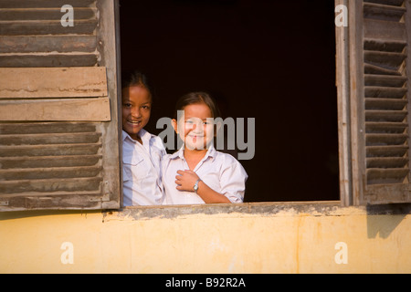 2 filles cambodgiennes smiling pour une photo à l'école secondaire Roesey Chroy sur la route d'Angkor Wat au Cambodge Banque D'Images