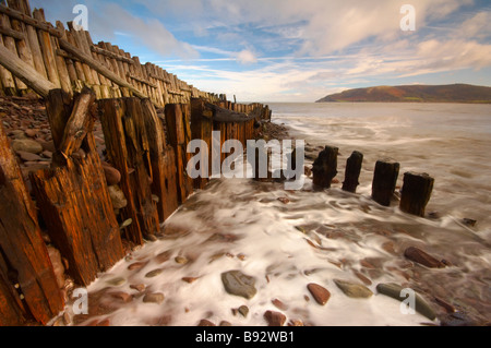 Les vagues se précipiter à travers bois épis sur le front de mer de Porlock Weir UK Somerset Exmoor Banque D'Images