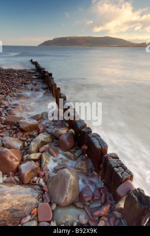 Les vagues se précipiter à travers bois épis sur le front de mer de Porlock Weir UK Somerset Exmoor Banque D'Images