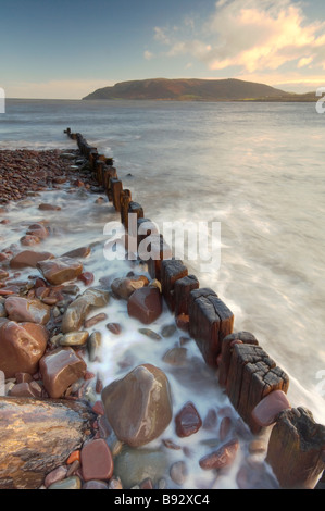 Les vagues se précipiter à travers bois épis sur le front de mer de Porlock Weir UK Somerset Exmoor Banque D'Images