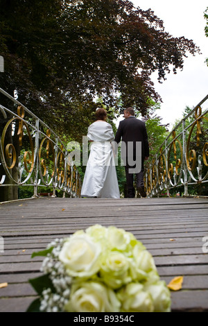Bouquet de mariage avec newly wed couple, mari et femme, marchant sur un pont à l'arrière-plan. Banque D'Images