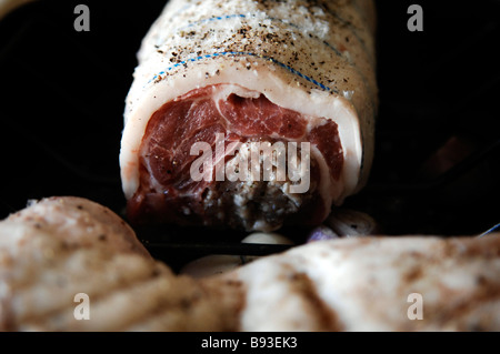 Une épaule de porc farcie de lard et prêt à rôtir dans un bac de torréfaction Banque D'Images