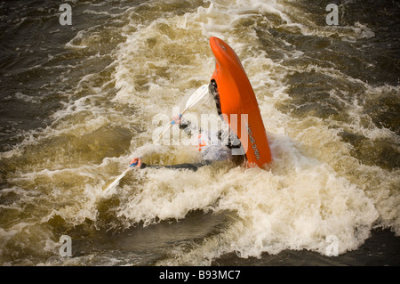 Kayakiste avec leur tête et la poupe du kayak submergé dans l'eau blanche et l'arc vertical. Tees barrage International White Water Centre. Banque D'Images