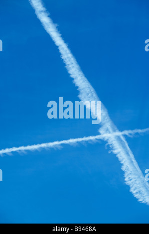 Ciel bleu avec des trainées de traverser les avions à réaction Banque D'Images