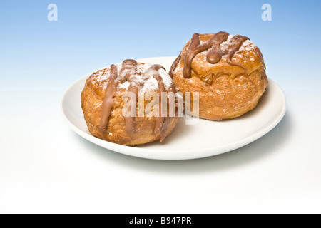 Brioches à la crème sur un fond bleu dégradé studio Banque D'Images