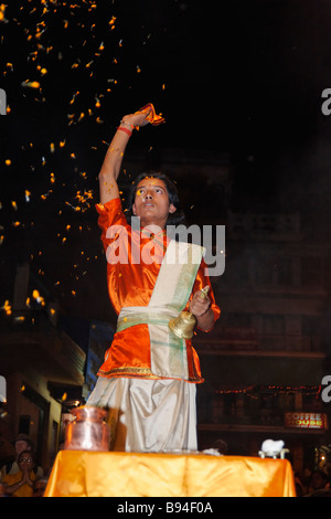 Prêtre hindou Brahman effectuant le coucher de fête au Gange Varanasi Banque D'Images