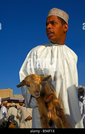 Les jeunes dans le vendeur de chèvre omanais costume national Dishdasha au marché de chèvre de Nizwa, Sultanat d'Oman Banque D'Images