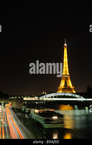 La nuit sur la Tour Eiffel avec le feu rouge les pistes de circulation et une station d'ferry Banque D'Images