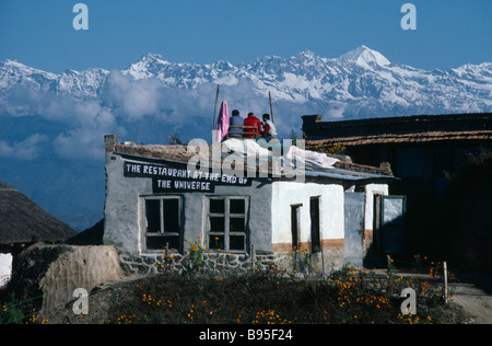 Asie Népal Himalaya Restaurant à la fin de l'Univers avec trois hommes assis sur le toit, entourée de montagnes aux sommets enneigés Banque D'Images