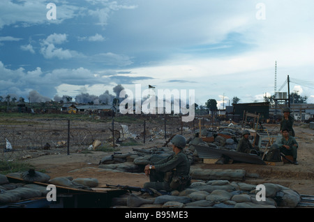 Guerre du Vietnam Central Highlands Siège de Kontum American B-52 bombarder derrière Kontum avec soldats montagnards assis au camp Banque D'Images