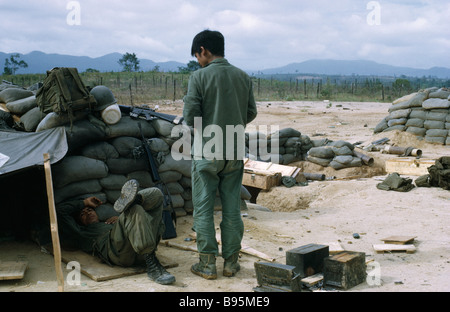 Guerre du Vietnam Central Highlands Siège de Kontum Hill Tribe Montagnard soldats au camp avec des sacs de sable et des abris de fortune Banque D'Images