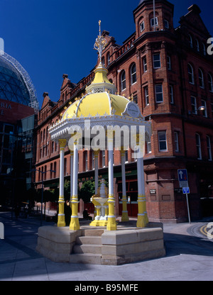 L'Irlande du Nord, Belfast, Square Victoria. Lit à baldaquin blanc et jaune Jaffe Fontaine avec extérieur en briques de Bittles Bar derrière. Banque D'Images