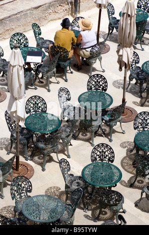 Malte La Valette deux personnes assis à une table entre autres tables et chaises en fer forgé dans la région Jardins Barrakka café ci-dessous Banque D'Images