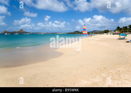 Antilles Caraïbes Sainte-Lucie Gros Islet plage de Reduit à Rodney Bay avec l'île Pigeon au-delà des touristes sur plage avec voile Banque D'Images