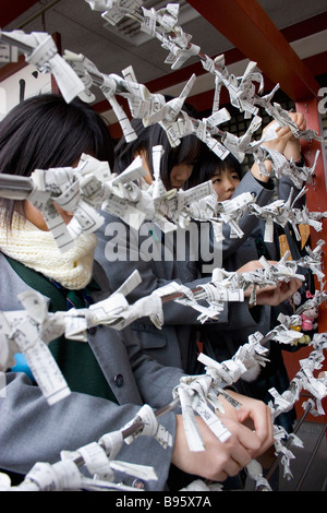 Le Japon Honshu Tokyo Asakusa Kannon Senso-ji ou Temple Shinto étudiantes japonais leur pendaison omikuji voyance paper Banque D'Images