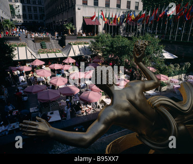 USA New York State Rockefeller Center de Manhattan café en plein air avec parasols et statue en or rose en premier plan Banque D'Images