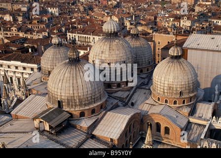 Italie, Vénétie, Venise. Vue sur des toits en dôme de la cathédrale avec des bâtiments de la ville étalée au-delà. Banque D'Images