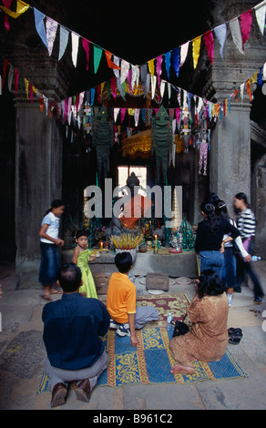 Cambodge La Province de Siem Reap Angkor Wat temple Banteay Kdei pèlerins cambodgiens au culte avec l'éclairage de l'encens Bouddha assis Banque D'Images