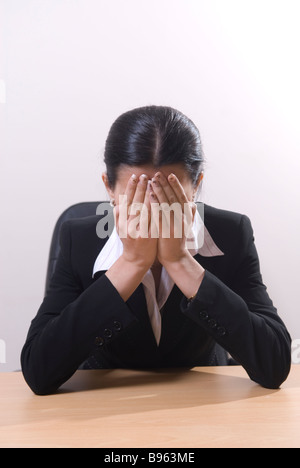 Business Woman sat in office de pleurer la tête dans les mains Banque D'Images