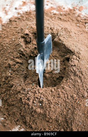 Le sable et le ciment de Portland ont été mélangés et la cosse est vu tournoyer dans le mélange de faire un trou pour l'eau Banque D'Images