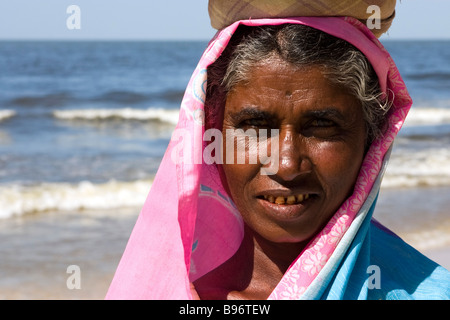 Portrait de plage femme portant une corbeille de fruits sur la tête. Banque D'Images