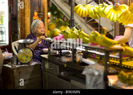 Vieille femmes asiatiques vente de produits au marché de Pratunam en soirée Bangkok Thaïlande Banque D'Images