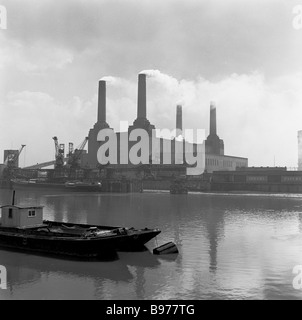 1950s, fumez les soufflets des quatre grandes cheminées d'une centrale électrique Battersea en activité, vue de la rive nord de la Tamise, Londres, Royaume-Uni. Banque D'Images