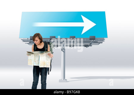 Woman looking at map et de l'affichage avec la flèche Banque D'Images