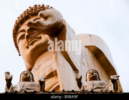 Immense statue de Bouddha à Taiwan, Fokuangshan, avec deux petites statues ci-dessous à la recherche de haut et en montrant des pécheurs Banque D'Images