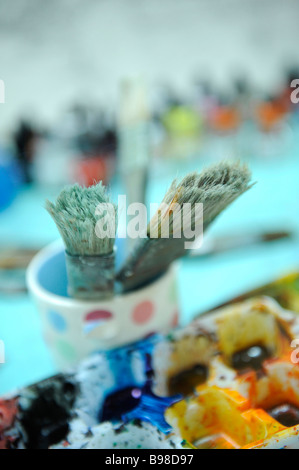 Un mélange de pots et de pinceaux utilisés par l'artiste mike bernard dans son studio nr Combe Martin Banque D'Images