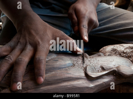 L'Afrique de l'Ouest BAMAKO Mali marché artisanal close up of hands travaillant sur sculpture en bois Banque D'Images