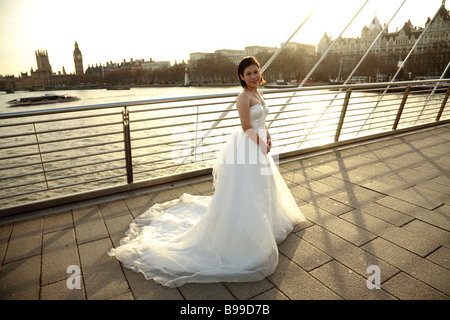 Un Asian bride en robe de mariage en face de la ville de Londres, Tamise et Westminster avec Big Ben Banque D'Images