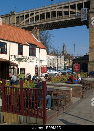 Bar Lloyds sur la rive de la rivière Tyne Newcastle avec le haut niveau historique route rail bridge derrière Banque D'Images