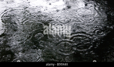 La pluie qui tombe sur la surface de l'eau Banque D'Images