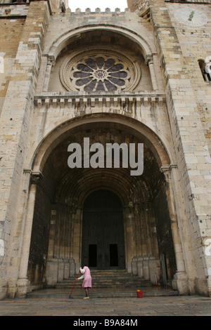 Une femme balaie les étapes de la Cathédrale de Lisbonne ou Santa Maria Maior de Lisboa mais communément appelé le Sé de Lisboa, Portugal Banque D'Images