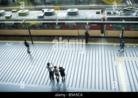 Les gens debout sur la plate-forme du train, en agitant, high angle view Banque D'Images