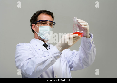 Scientist examining liquid in beaker Banque D'Images