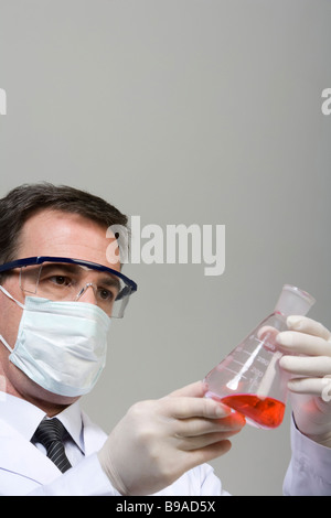 Scientist examining liquid in beaker Banque D'Images