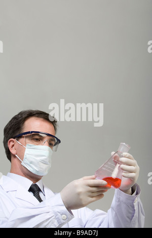 Scientist examining liquid in beaker Banque D'Images