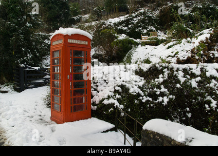 Vieux téléphone rouge fort dans la neige dans la campagne Banque D'Images