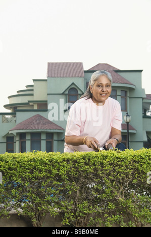 Femme de couverture de fraisage dans un jardin, New Delhi, Inde Banque D'Images