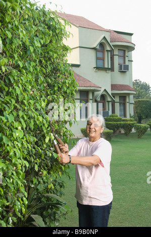 Femme de couverture de fraisage dans un jardin, New Delhi, Inde Banque D'Images