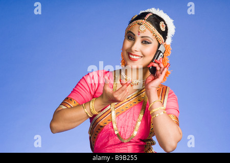 Danseuse de parler sur un téléphone mobile dans l'exécution de Bharatnatyam et Banque D'Images