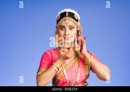 Danseuse de parler sur un téléphone mobile dans l'exécution de Bharatnatyam et Banque D'Images